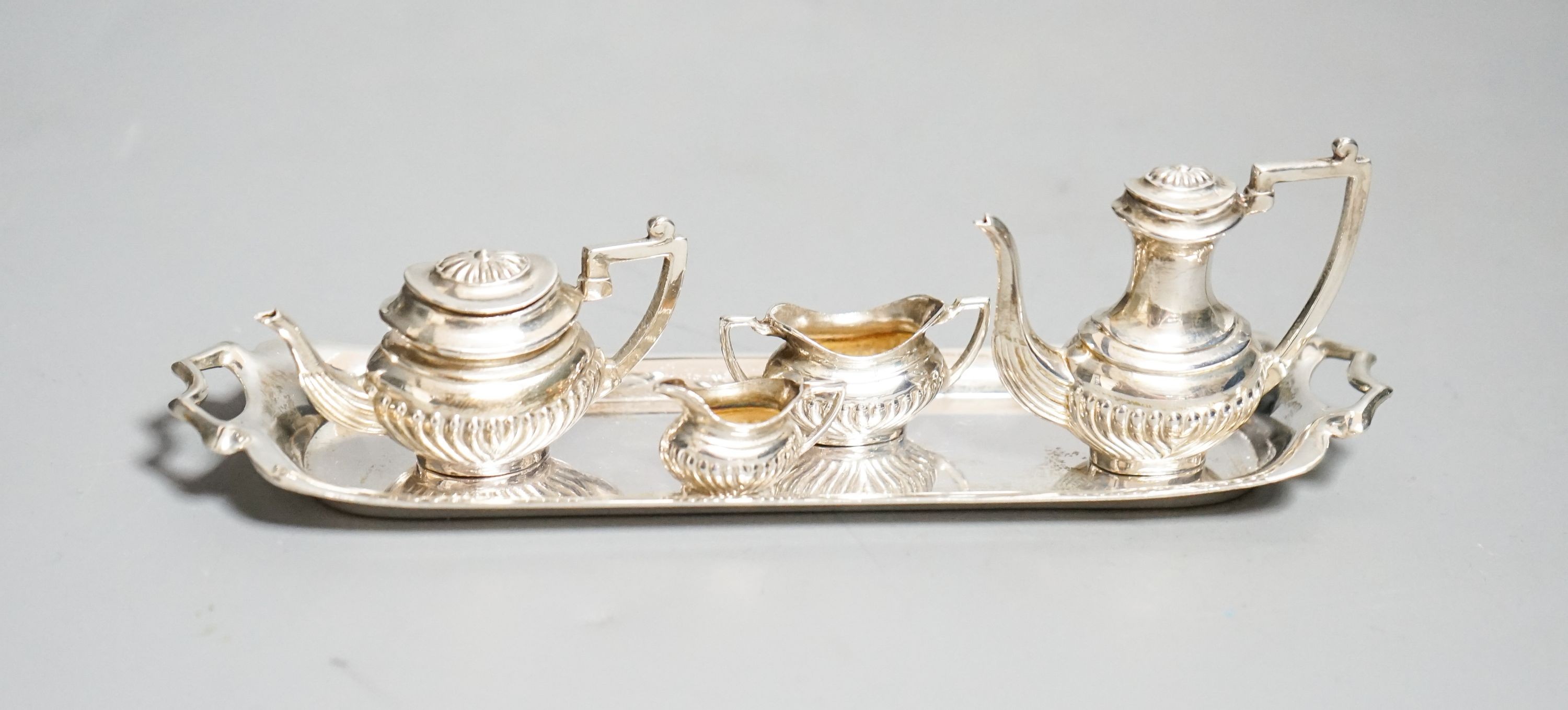A modern silver miniature four piece tea set and two handle tea tray, London, 1979, tray 14.8cm.